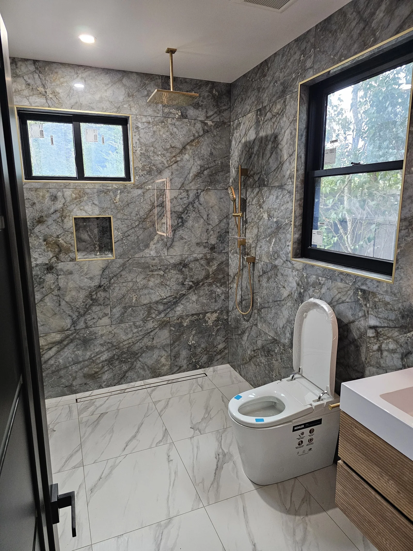 Hillsborough ADU, book-matched marble bathroom with brass fixtures, January 2026
